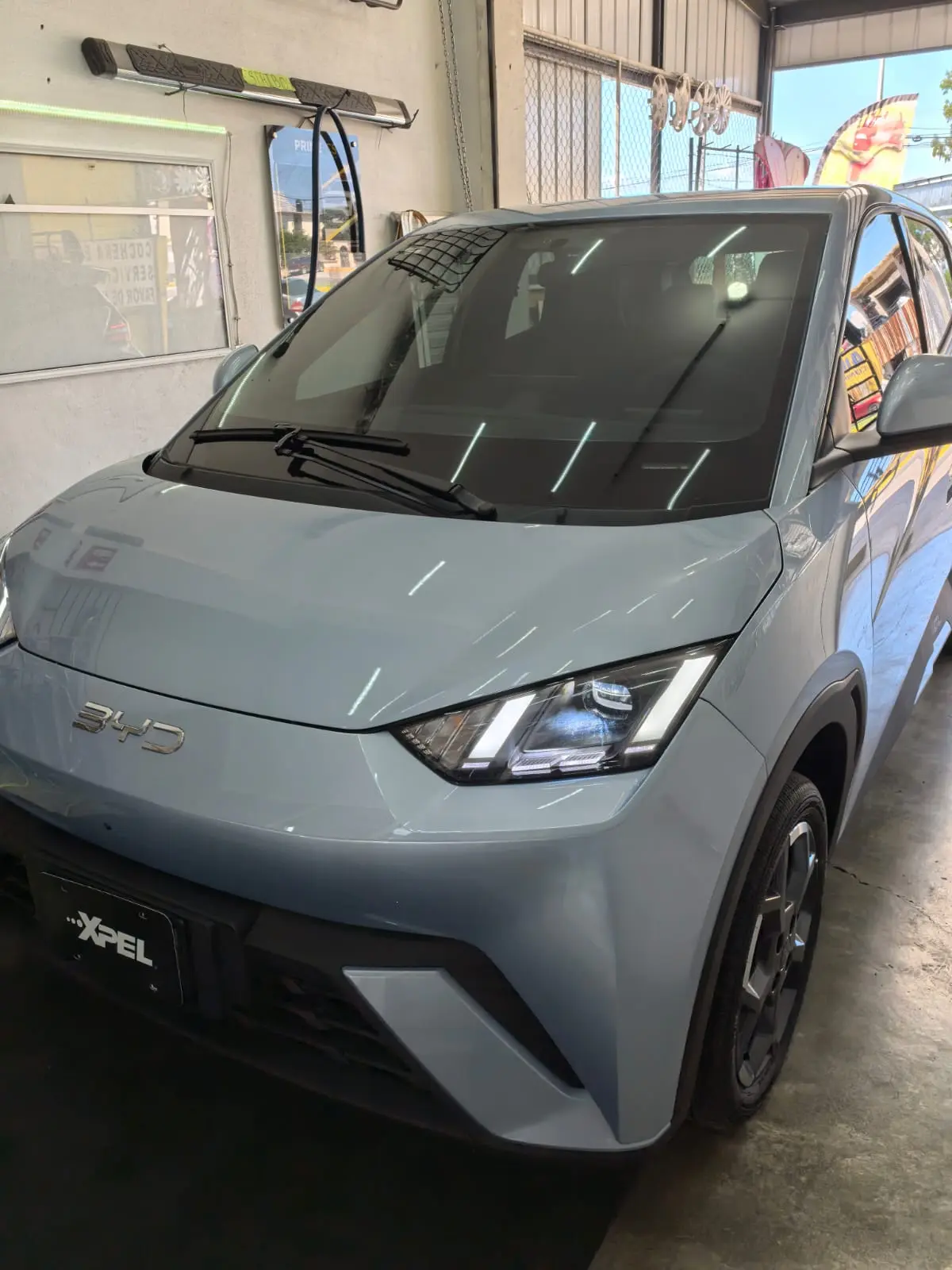 Auto eléctrico BYD azul claro con polarizado frontal