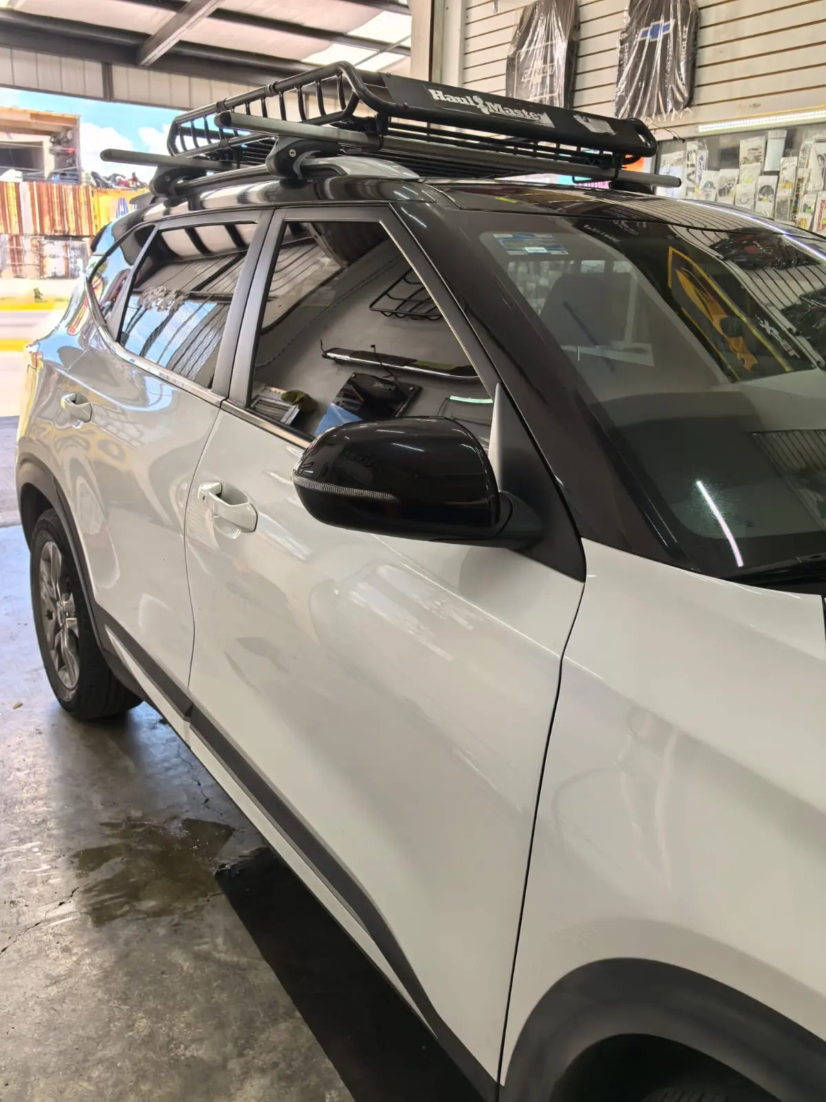 Kia Seltos blanca con canastilla de techo y vidrios oscuros