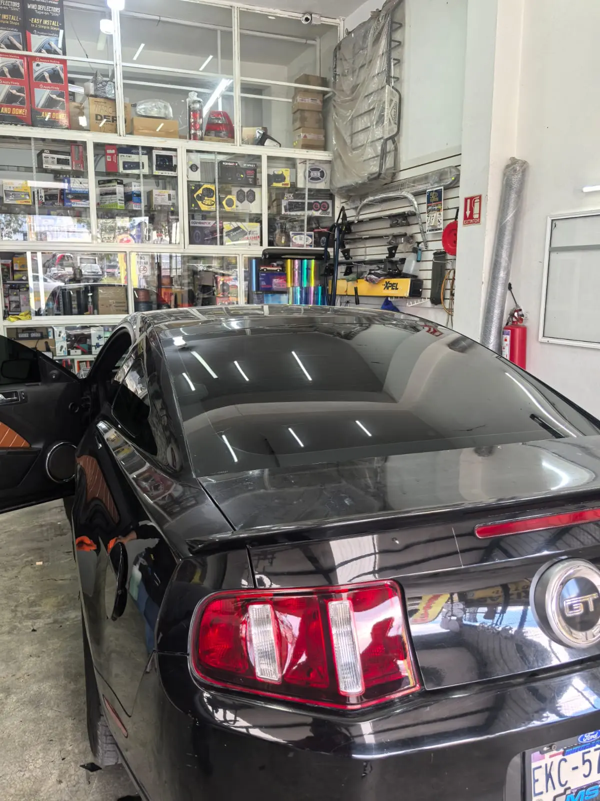Ford Mustang GT negro con vidrios polarizados en el taller